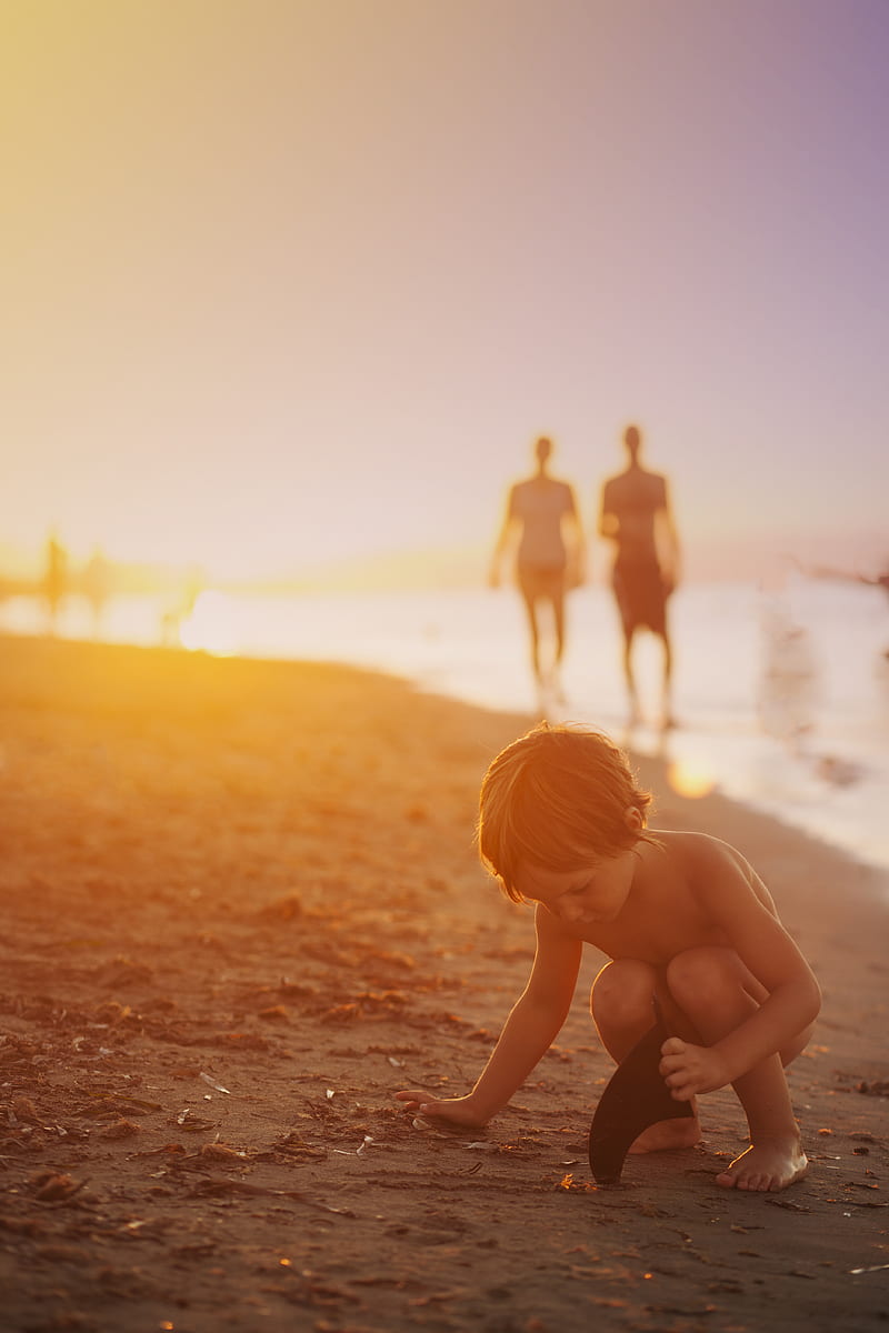 boy playing sand on seashore during sunset, HD phone wallpaper