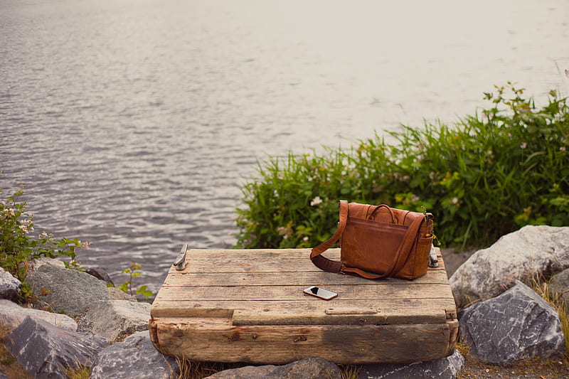 brown leather crossbody bag on brown wooden panel near water, HD wallpaper