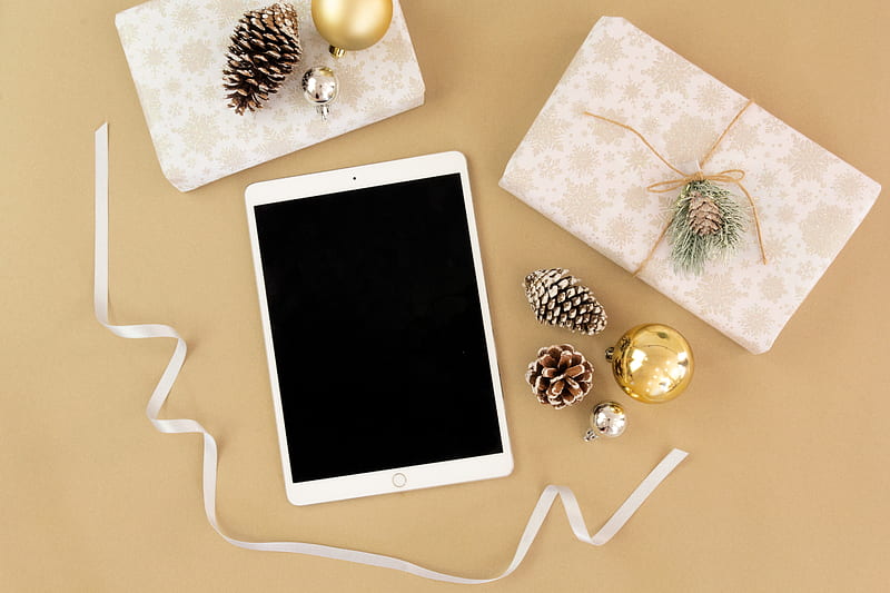 gold iPad near brown pinecone, gold bauble, white ribbon, and beige gift box, HD wallpaper