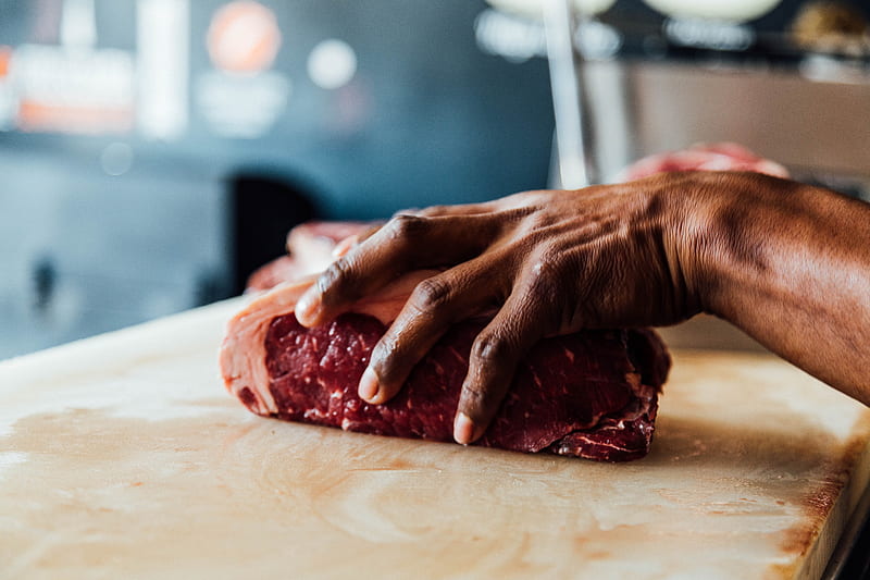 A butcher holding a piece of meat in his hand in Boca del Río, HD wallpaper