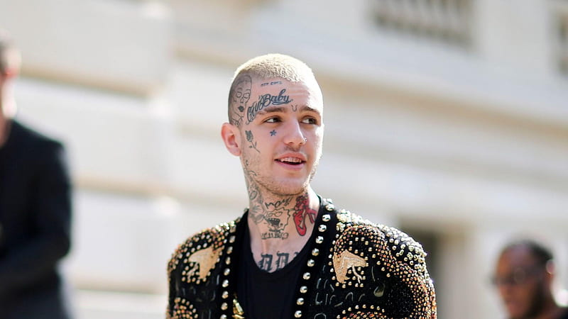 lil peep is standing in blur background wearing black coat and having tattoos on face and neck facing one side music, HD wallpaper