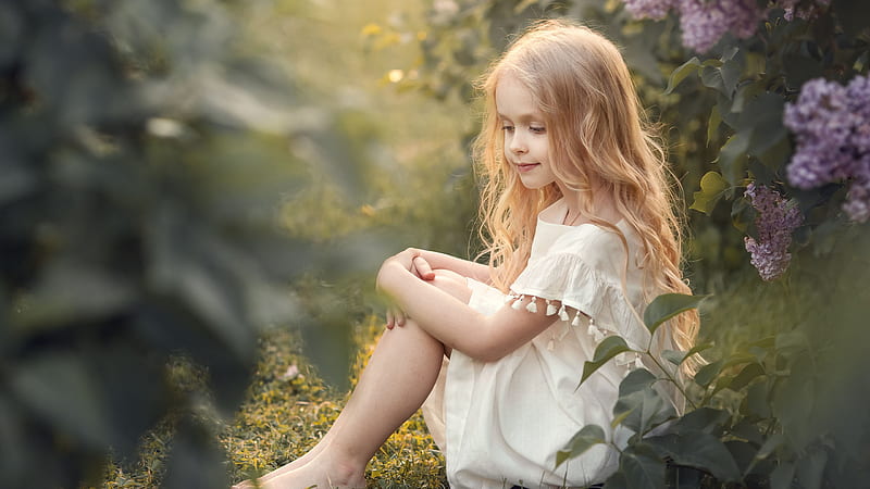 Cute Little Girl Is Sitting On Grass Looking Down Wearing White Dress In Blur Green Leaves Background Cute, HD wallpaper
