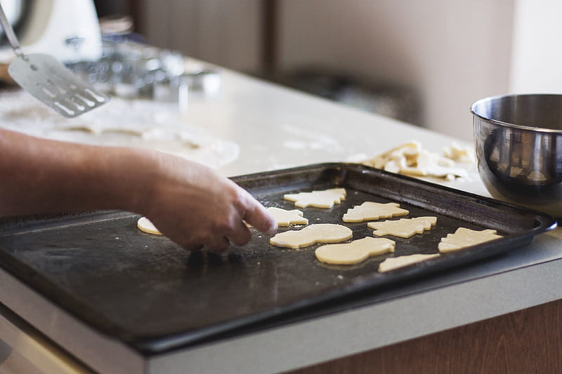 person lining assorted-shaped cookies on baking sheet inside kitchen, HD wallpaper