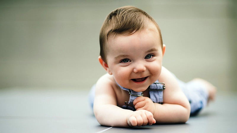 Cute Smiley Baby Is Lying Down On Floor Wearing Light Blue Dress In A Blur Background Cute, HD wallpaper
