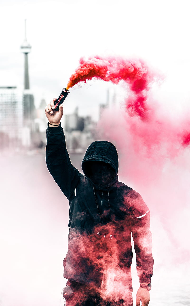 person wearing black and red hoodie holding smoke bomb, HD phone wallpaper
