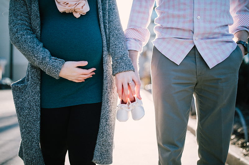 man standing beside pregnant woman holding baby's shoes during daytime, HD wallpaper