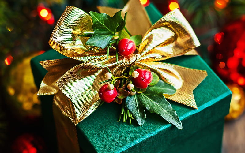 Stylish christmas gift wrapped in gold paper and green ribbon, festive  decorations on green Stock Photo by Sonyachny