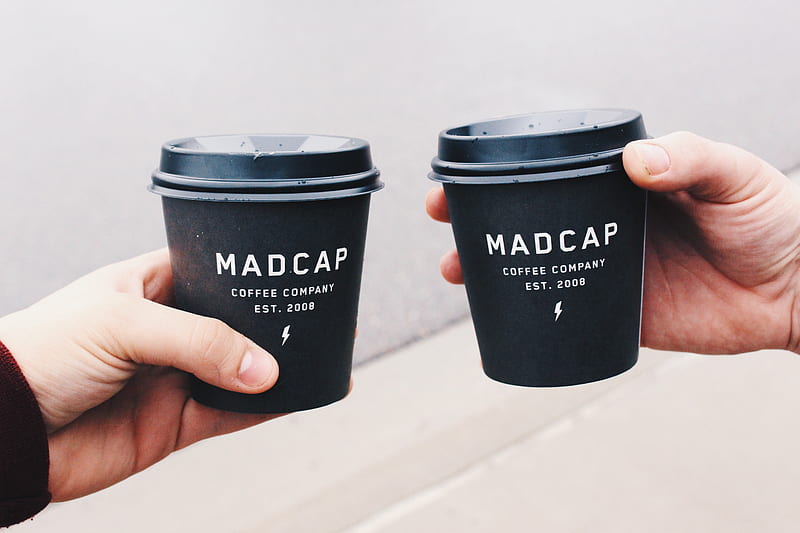 two person holding black Madcap coffee disposable cups, HD wallpaper