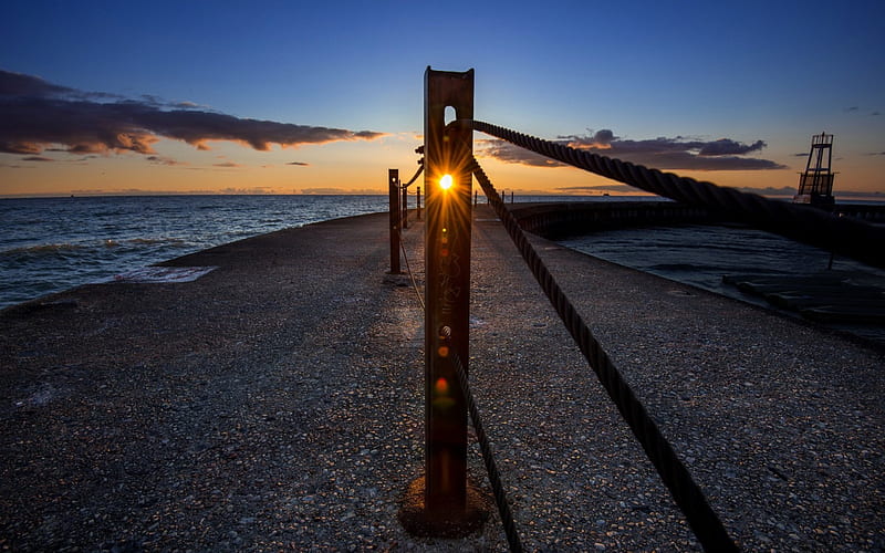 sunset through a metal post on a pier, chain, pier, sunset, posts, sea, HD wallpaper