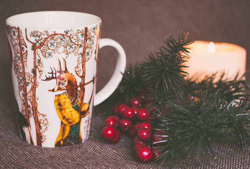 white and brown print ceramic mug near red mistletoe and candle, HD wallpaper