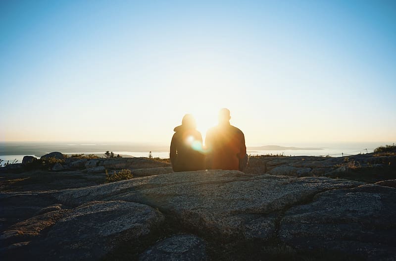 A couple sits atop a rocky mountain at sunrise, sun, rocks, sunset, mountain, sunrise, cold, golden hour, romance, elevation, mountaintop, couple, sky, HD wallpaper