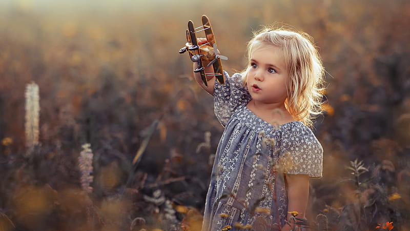 Cute Little Girl Is Standing In The Middle Of Flowers Field Wearing Printed Frock Playing With Toy Cute, HD wallpaper
