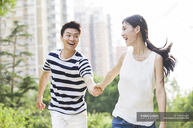 Young Chinese couple holding hands while walking in park, HD wallpaper