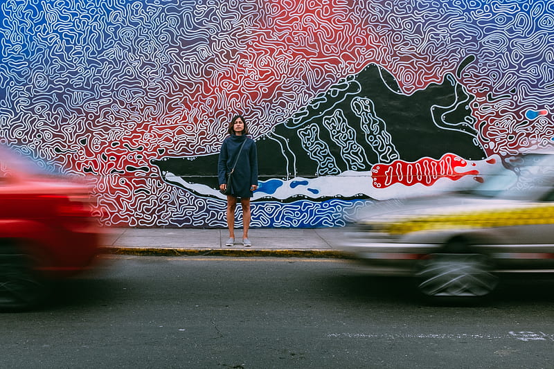 time lapse graphy of woman wearing blue jacket standing on concrete pathway in front of two vehicles passing on concrete road during daytime, HD wallpaper