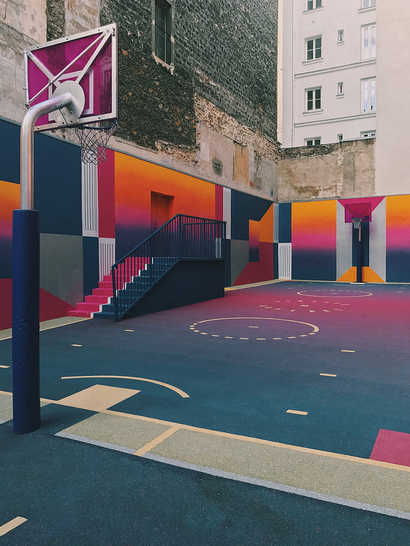 black, purple, and orange basketball court beside concrete buildings at daytime, HD phone wallpaper