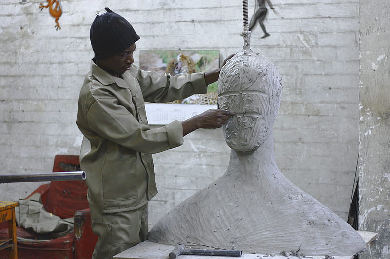 A sculptor works in his studio sculpting a large white body and head, HD wallpaper