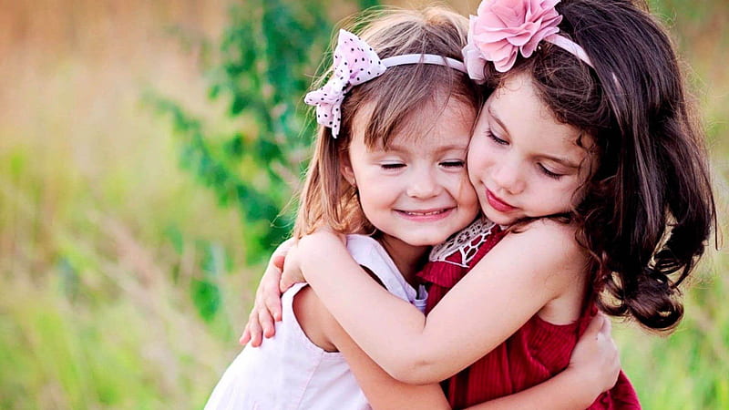 Cute Two Little Girls Are Hugging Each Other Wearing Red And White Dress And Headbands In Green Blur Background Cute, HD wallpaper