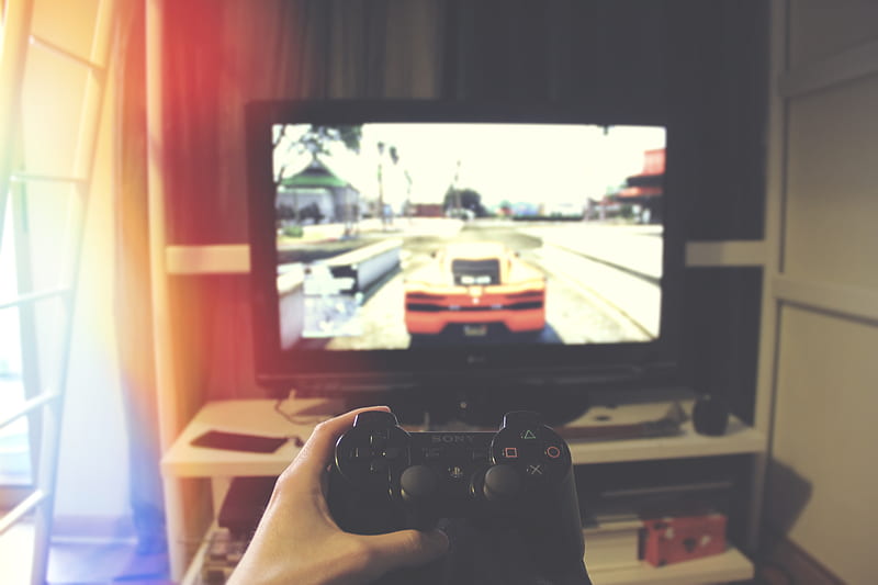 person holding Sony PS3 controller in front of flat screen monitor, HD wallpaper