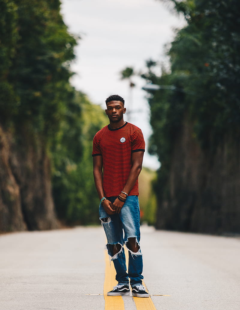 man in red shirt and blue distress denim jeans standing in middle of road, HD phone wallpaper