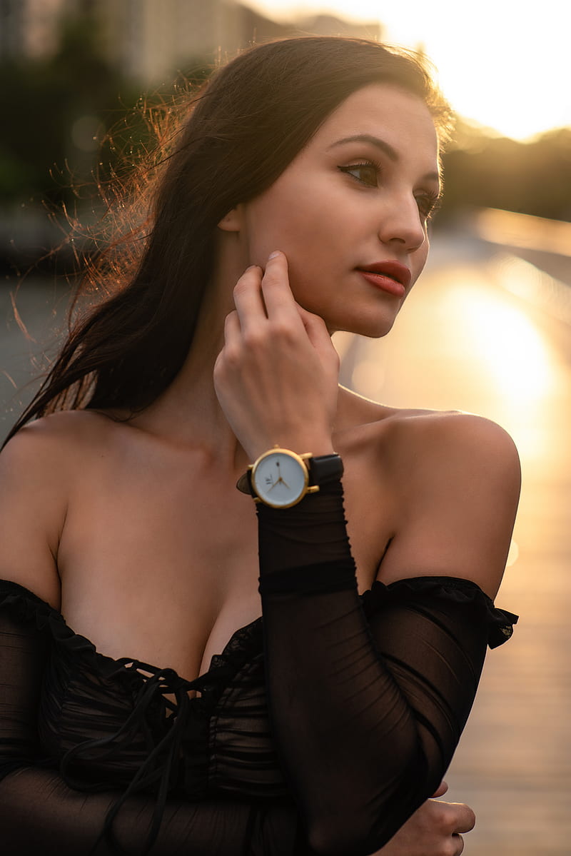 Jenna Glamour, women, model, brunette, brown eyes, looking away, touching face, watch, bare shoulders, dress, black dress, backlighting, sunset, outdoors, depth of field, portrait display, face, cleavage, women outdoors, Christopher Rankin, HD phone wallpaper