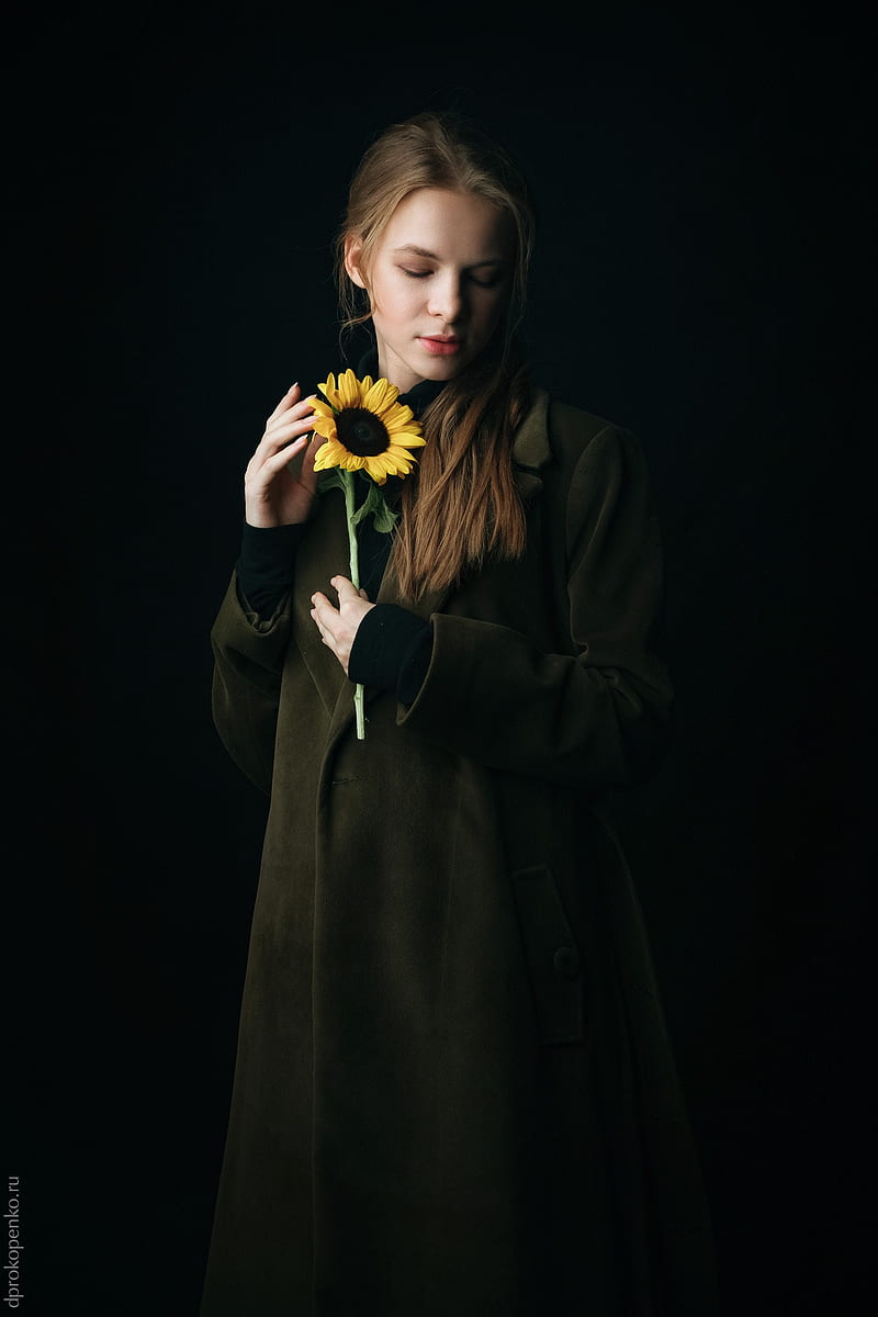 dark, women, flowers, sunflowers, yellow flowers, model, simple background, green coat , coats, Irina Regent, pale, looking below, Irina, Irina (model), HD phone wallpaper