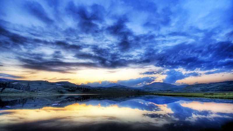 Blue Cloudy Sky Above Calm Body Of Water With Reflection And Landscape ...