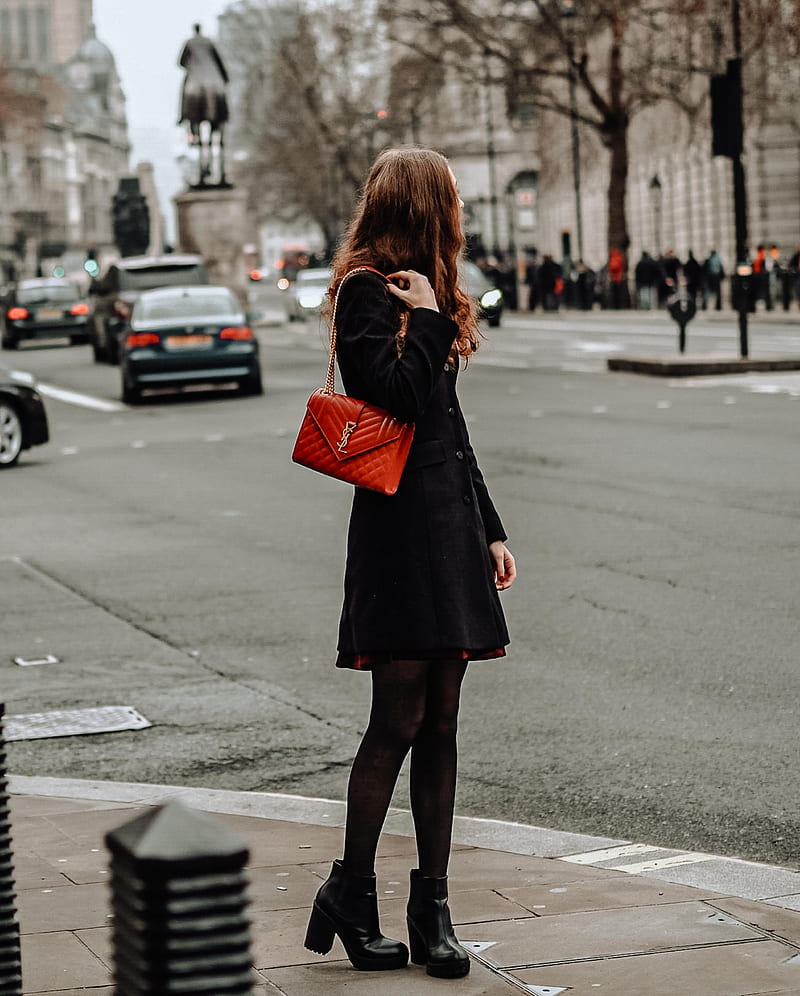woman in black coat and red leather sling bag standing on sidewalk during daytime, HD phone wallpaper