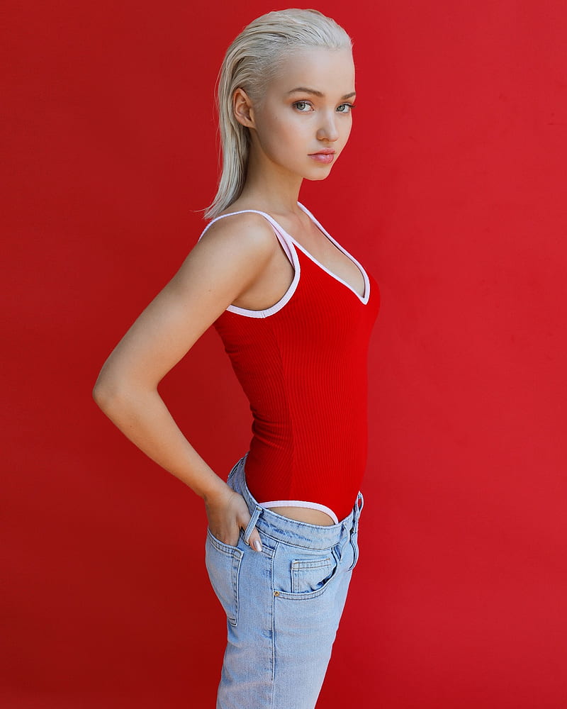 Dove Cameron, women, actress, singer, blonde, green eyes, jeans, hands in pockets, red, red background, profile, Red tank top, HD phone wallpaper