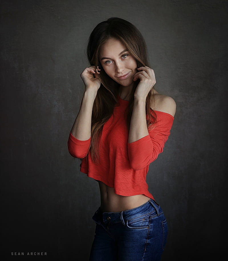 Sean Archer, model, , women, simple background, Olga Katysheva, holding hair, red tops, smiling, jeans, touching face, HD phone wallpaper