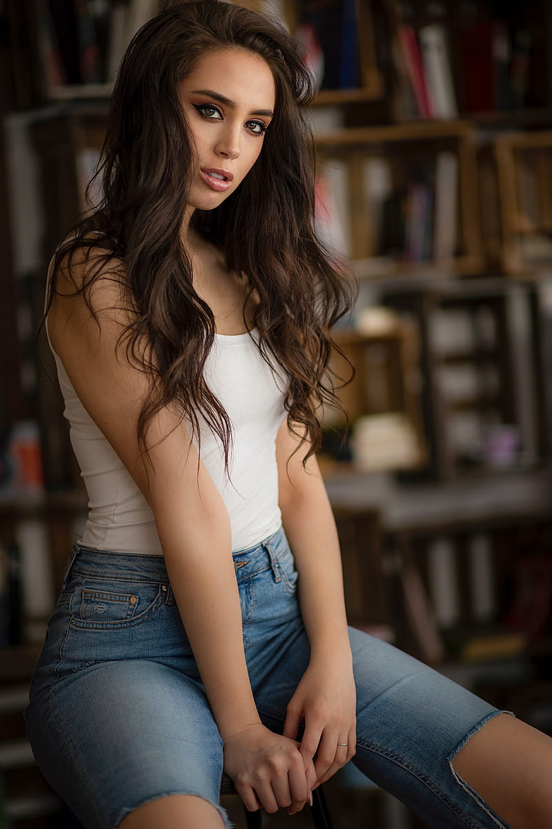 Anna Bous, women, brunette, long hair, model, brown eyes, looking at viewer, eyeliner, portrait display, vertical, white tops, jeans, torn jeans, ripped clothes, sitting, depth of field, indoors, women indoors, Chris Bos, books, HD phone wallpaper