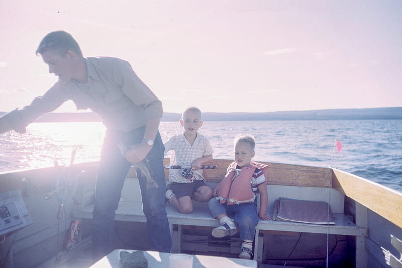 man holding gray fish standing beside two boys sitting on boat seats, HD wallpaper