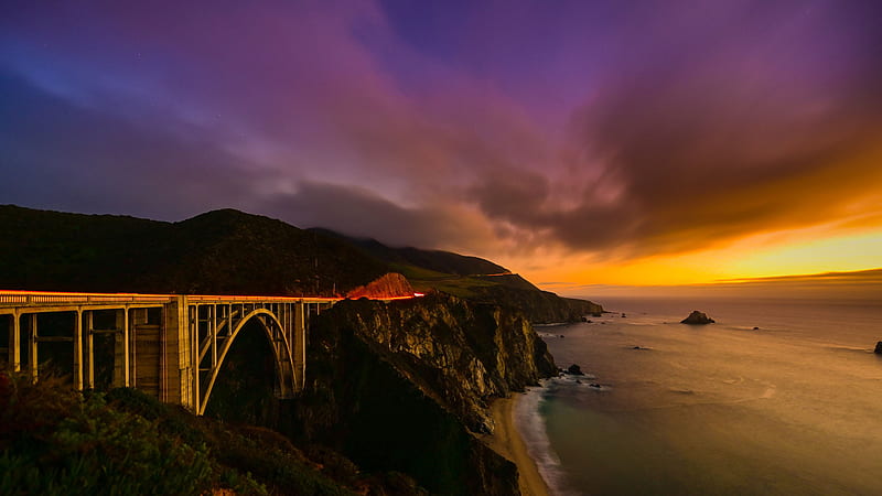 Bridge Between Rock And Mountains Near Ocean Under Purple Black Yellow Cloudy Sky Nature, HD wallpaper