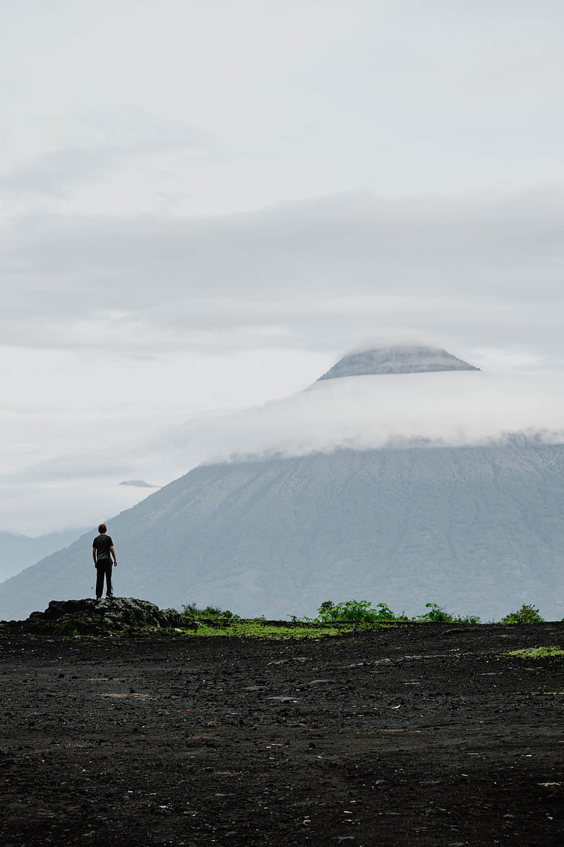 silhouette of man standing on rock facing volcano, HD phone wallpaper