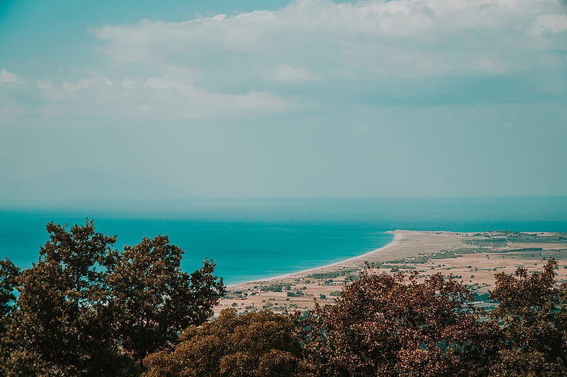 Green Trees Near Blue Sea Under White Clouds And Blue Sky During