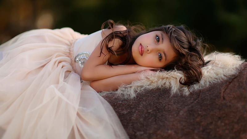 Cute Little Girl Is Lying On Rock Wearing Frock In Blur Green Background Cute, HD wallpaper