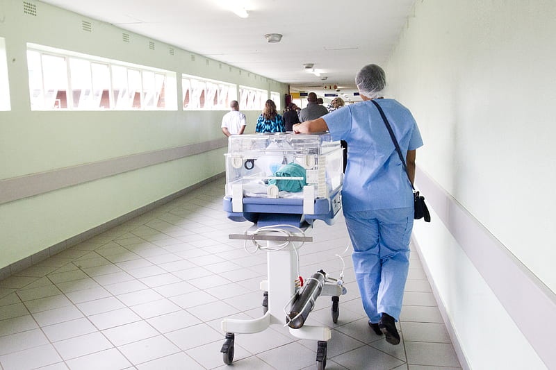 person walking on hallway in blue scrub suit near incubator, HD wallpaper