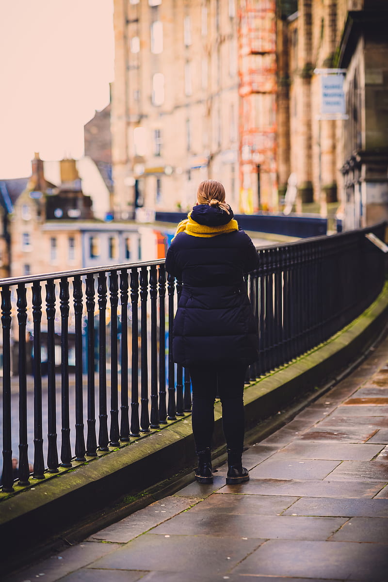 woman in black and yellow jacket standing on sidewalk during daytime, HD phone wallpaper