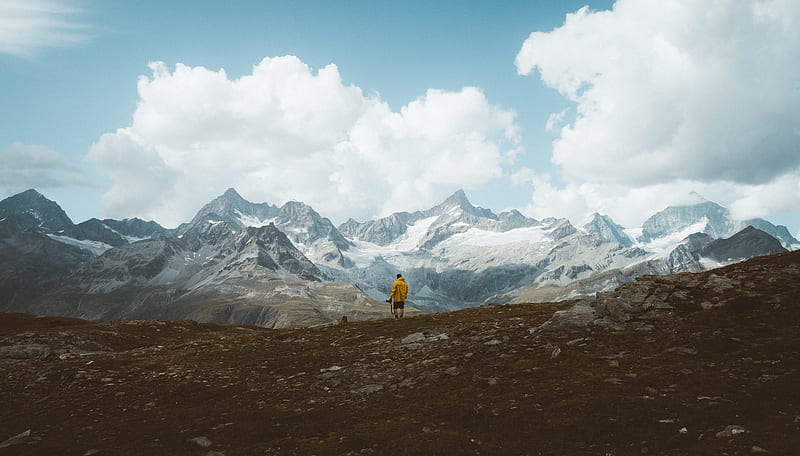 person in yellow jacket walking on brown field near snow covered mountain during daytime, HD wallpaper