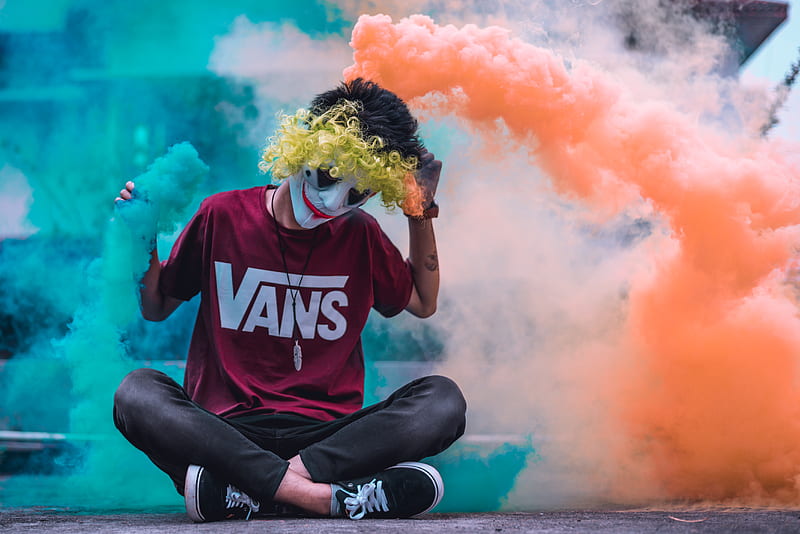 face painted man sitting on ground surrounded by orange and green smoke, HD wallpaper