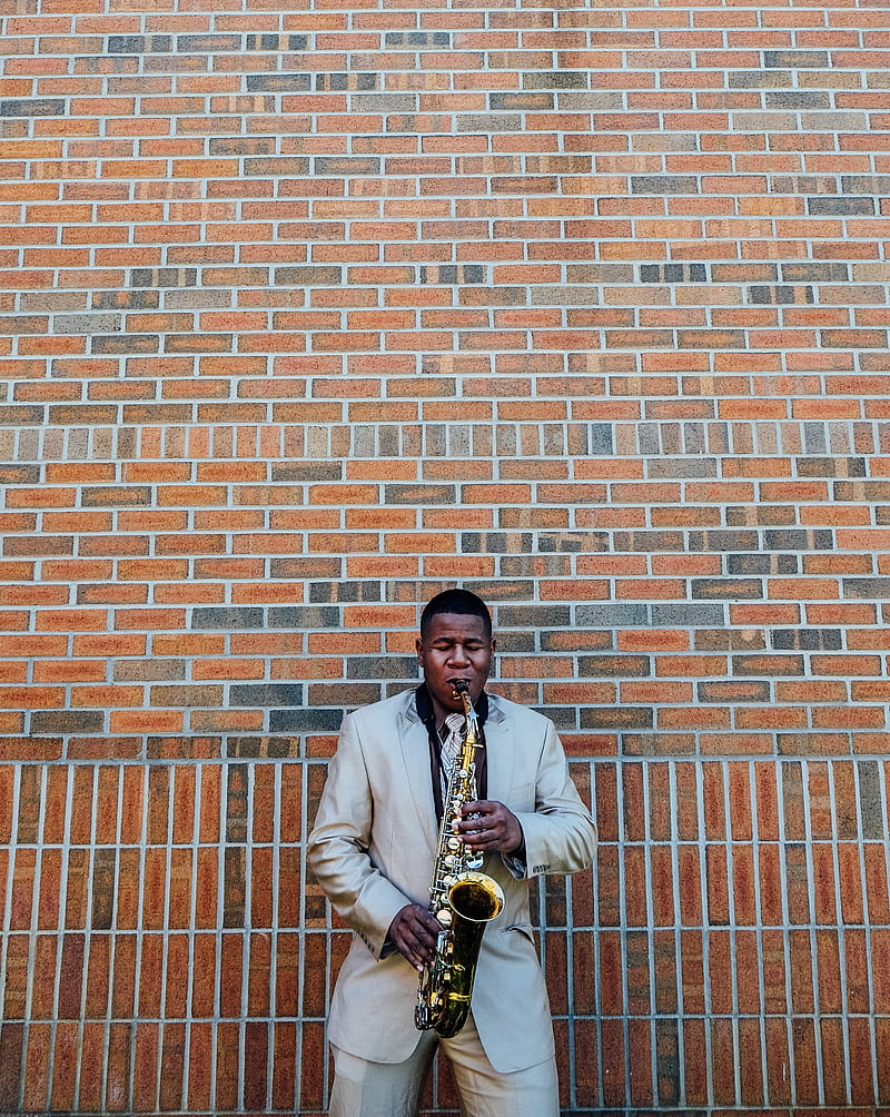 man playing saxophone near concrete brick, HD phone wallpaper