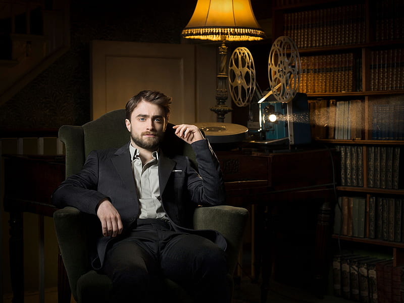 Daniel Radcliffe, projector, lamp, costume, books, pose, in the chair, twilight, a beam of light, hoot, shelves, sitting, actor, light, HD wallpaper