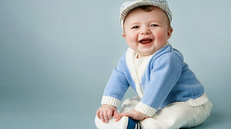 smiley cute baby boy is sitting on floor wearing white dress and cap with blue woolen sweater in blue background cute, HD wallpaper