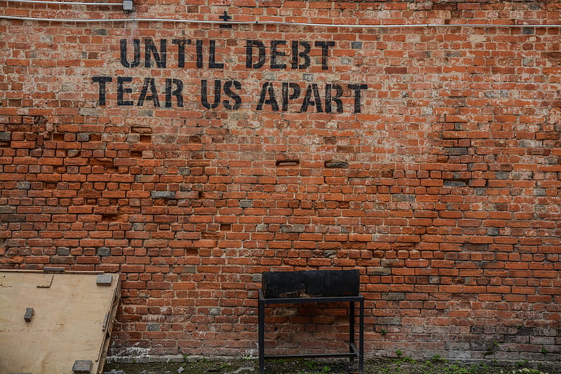 Until debt tear us apart printed red brick wall at daytime, HD wallpaper