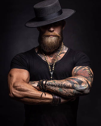 Bearded man with tattoo on chest and arms. Fashion style and trend. Tattoo  model with beard on unshaven face. Tattooed man with biceps and triceps.  Fashion macho in trendy sunglasses Stock Photo
