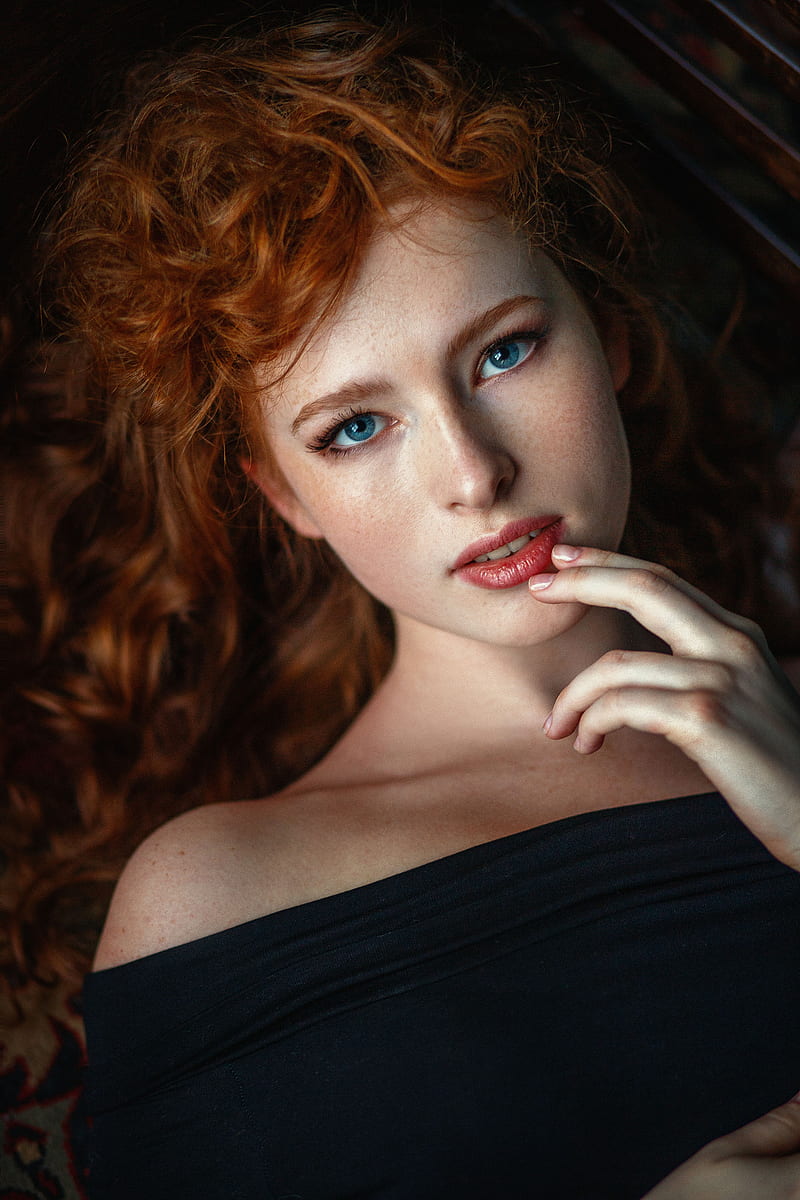Nastasya Parshina, women, redhead, long hair, curly hair, freckles, blue eyes, looking at viewer, hand on face, makeup, lipstick, open mouth, bare shoulders, black clothing, portrait, finger on lips, HD phone wallpaper