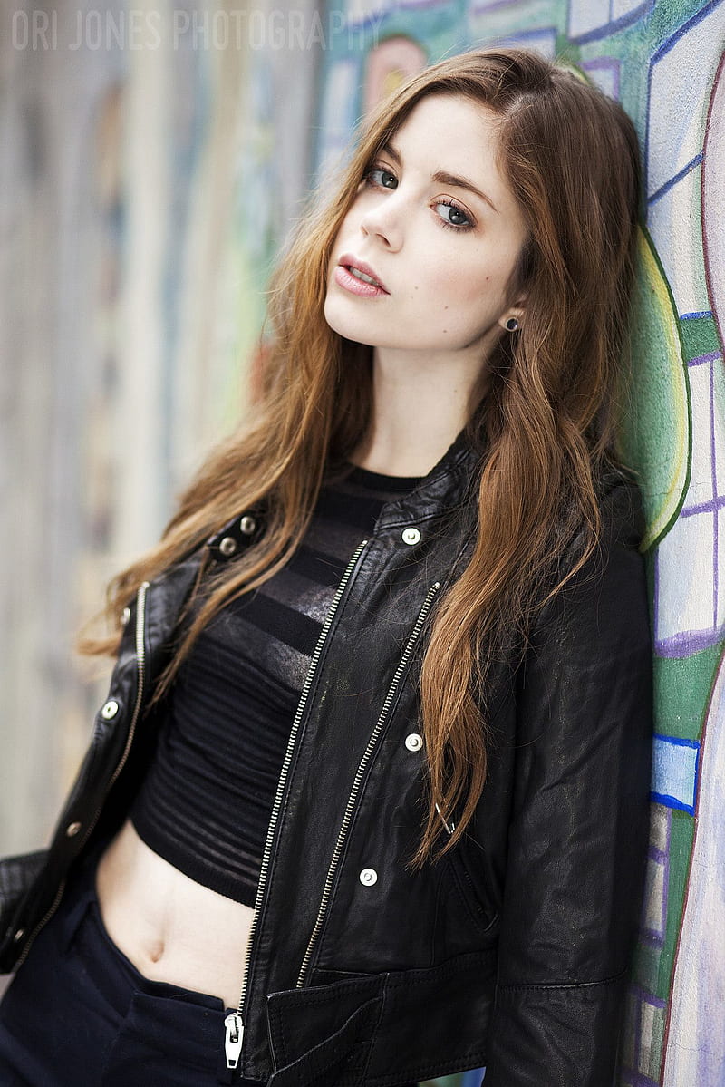 Charlotte Hope, women, actress, brunette, long hair, blue eyes, British, urban, women outdoors, leather jackets, black jackets, belly, hair covering eyes, looking at viewer, pale, jacket, open jacket, young woman, HD phone wallpaper
