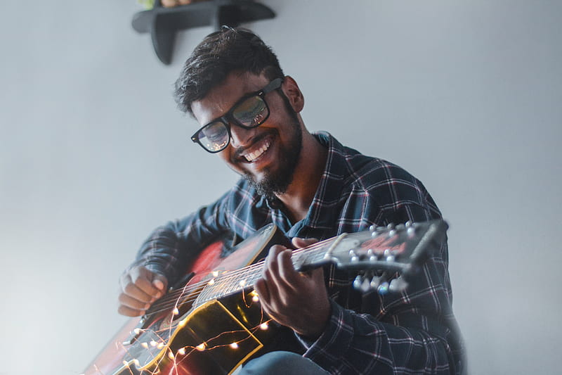 smiling man sitting while playing guitar, HD wallpaper