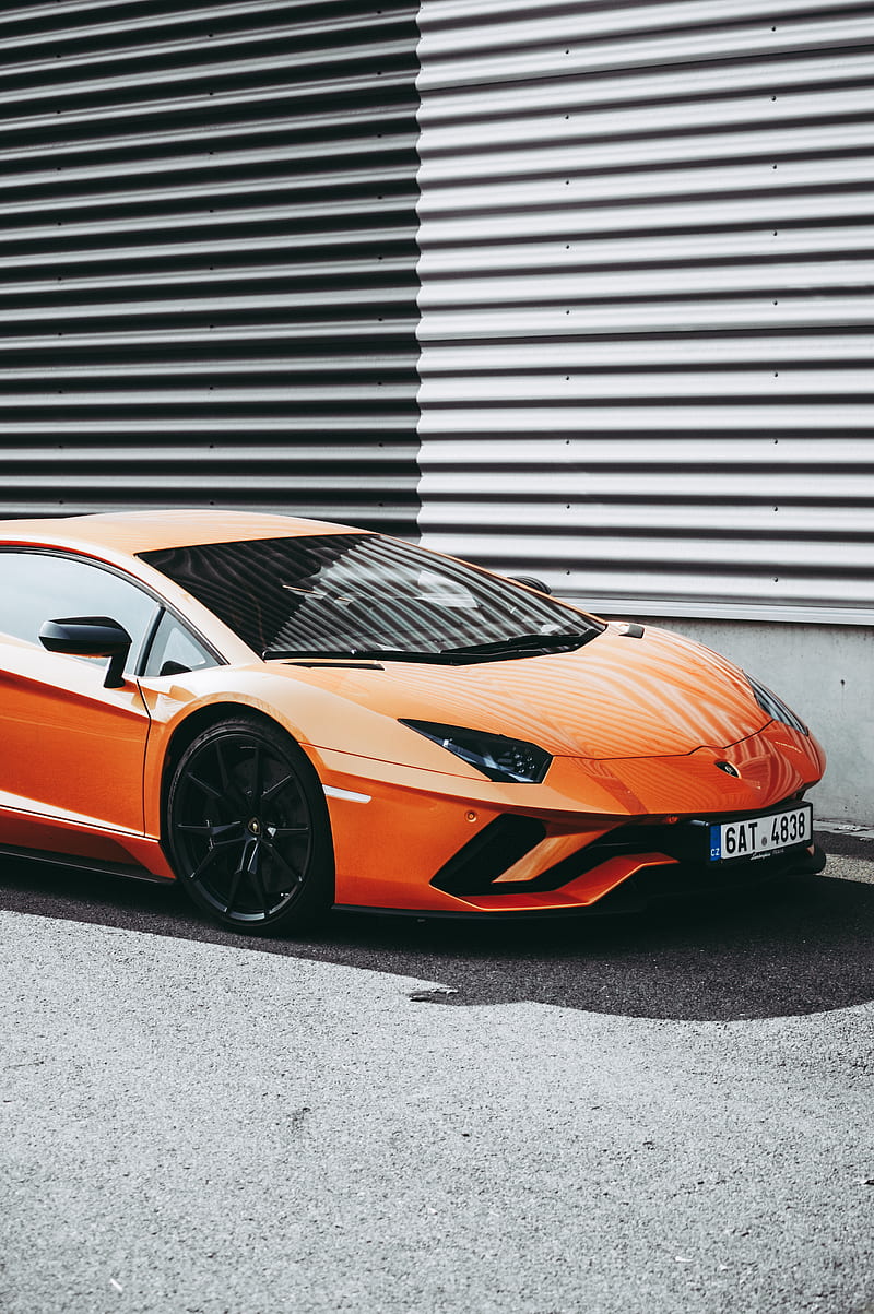 orange Lamborghini sports coupe parked near corrugated wall at daytime, HD phone wallpaper
