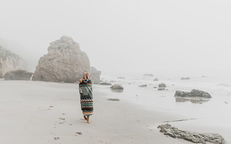 Full body of barefoot female traveler strolling on wet sandy coast against rocky cliff in misty weather, HD wallpaper