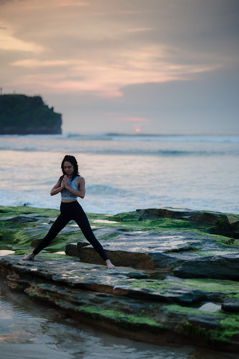 woman doing yoga on rock platform next to body of water, HD phone wallpaper